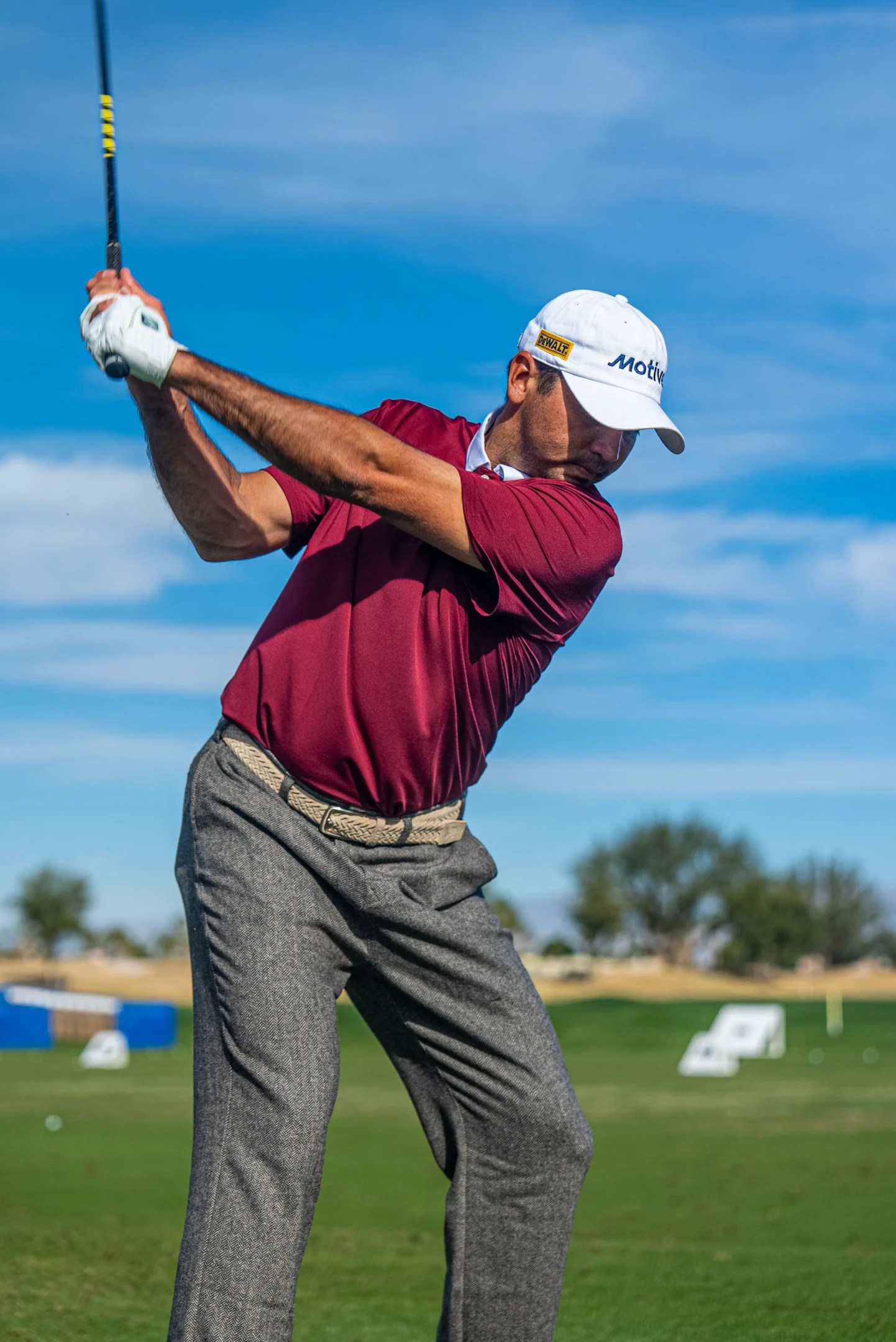 jason day swinging golf club in white motive hat
