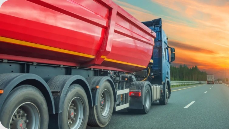 dump truck on highway with sunset in background