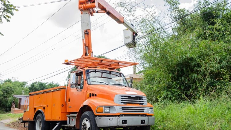 orange bucket truck servicing phone and power lines power lines