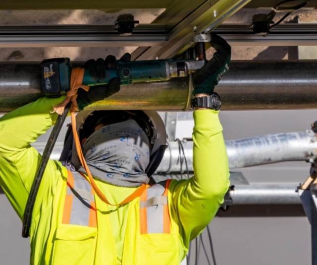 utility worker in safety gear working on pipe