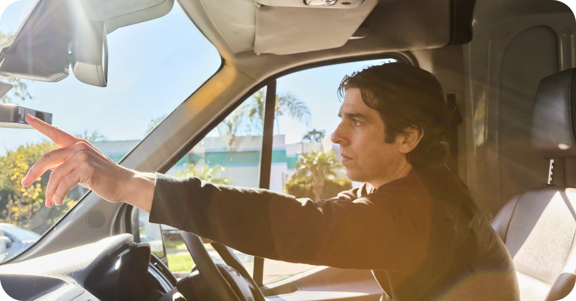 Vehicle driver turning on Motive's AI Dashcam Plus (AIDC+) to record video.